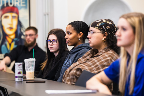 Students sitting at long table having a class discussion
